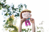 Gloria Gardener plush in outdoor garden setting - hands-on learning about plants and nature