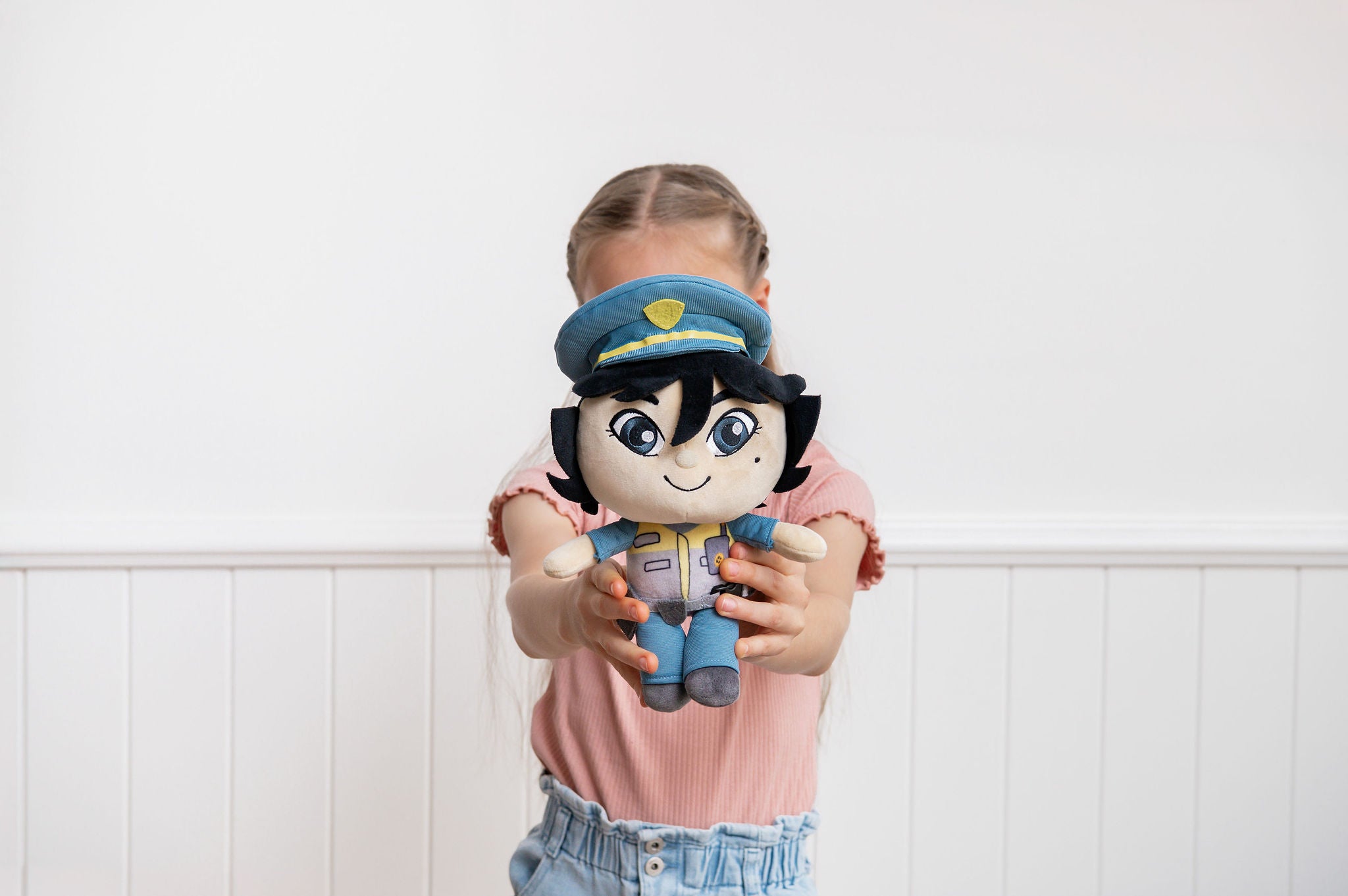 Child playing with Pippa Police Officer doll indoors - educational police career toy for imaginative play